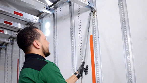 Driver raising deckbar inside trailer